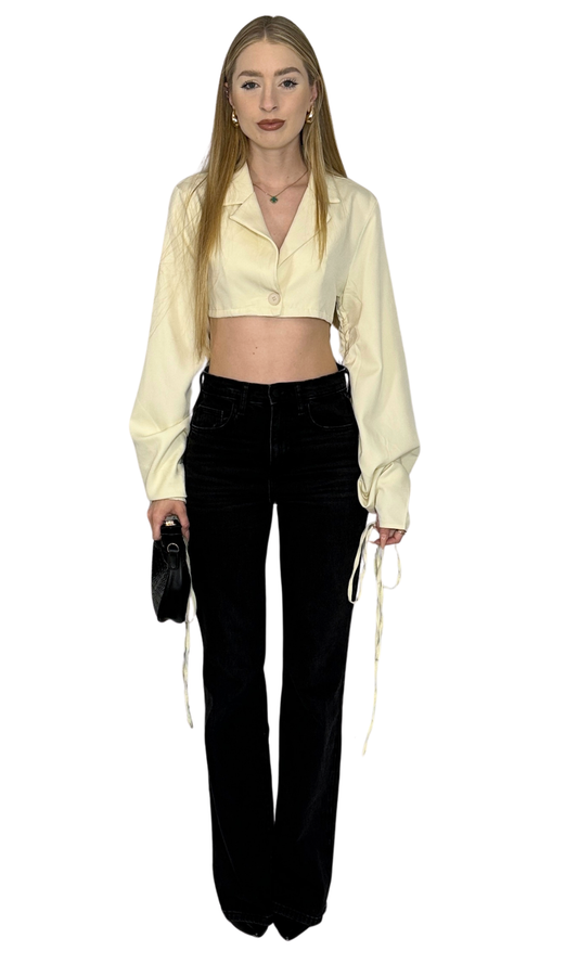 Beige cropped blazer top with oversized sleeves and drawstring detailing, offering a chic and modern twist on a classic silhouette.