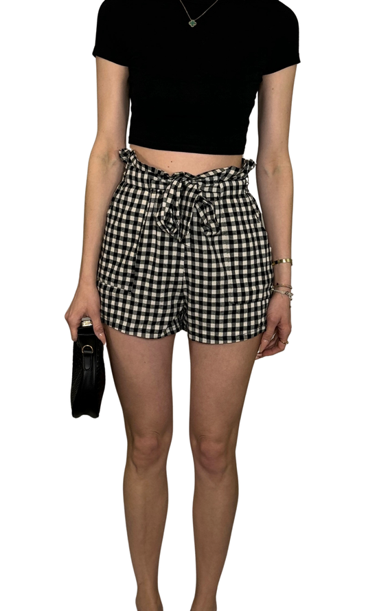 Women's black and cream checkered shorts with elastic waistband, front pockets, and tie belt sash – casual and comfortable fit