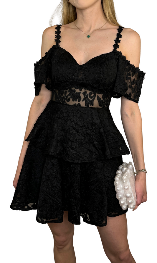 Black ruffle dress featuring open shoulders, a mesh front panel, intricate embroidery throughout the skirt and bodice layers, and a hidden back zipper, perfect for creating an unforgettable look on any occasion.