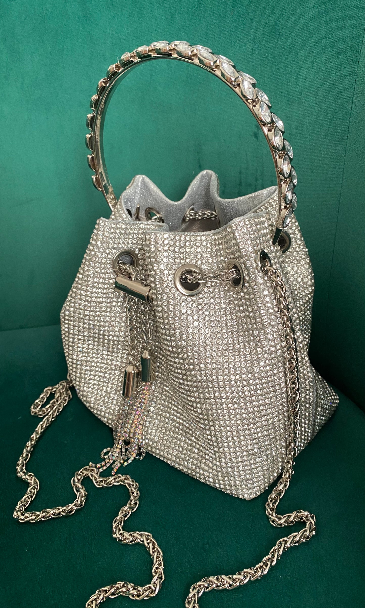 Elegant crystal bag with full rhinestone design, detachable chain strap, and hard crystal metal handle for a sparkling statement accessory.