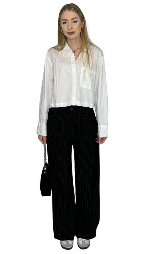 Women's black and white pinstriped trousers with elastic back, front pockets, and button closure – stylish and comfortable for professional wear