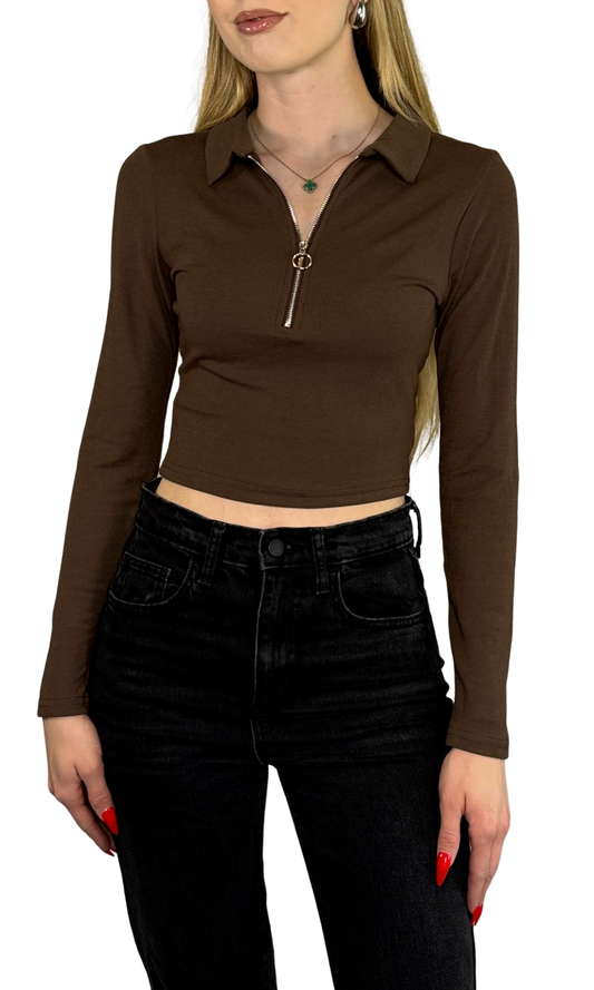 Long sleeve crop top made from soft, ribbed fabric featuring a front zipper for adjustable fit and added convenience.