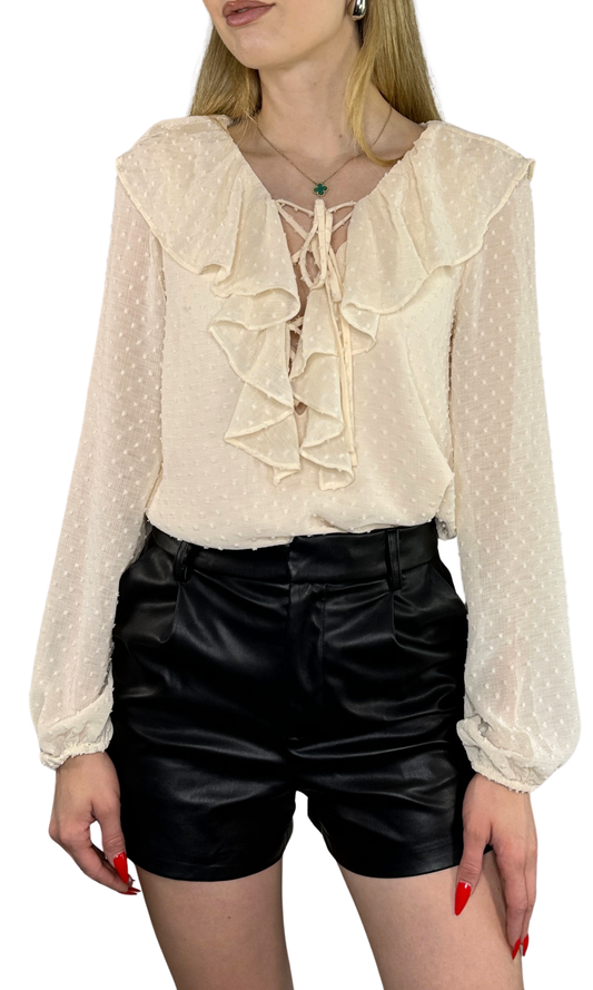 Adjustable Swiss dot blouse with a ruffled lace-up front, elastic sleeves, and a flirty feminine design, available in black and ivory.