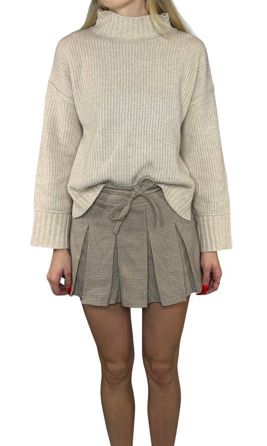 Vienna Mini Skirt in light taupe plaid featuring a high waist, delicate pleats, belt loop waist tie, side zipper, and built-in shorts. A sophisticated and versatile skirt perfect for both daytime and evening wear.