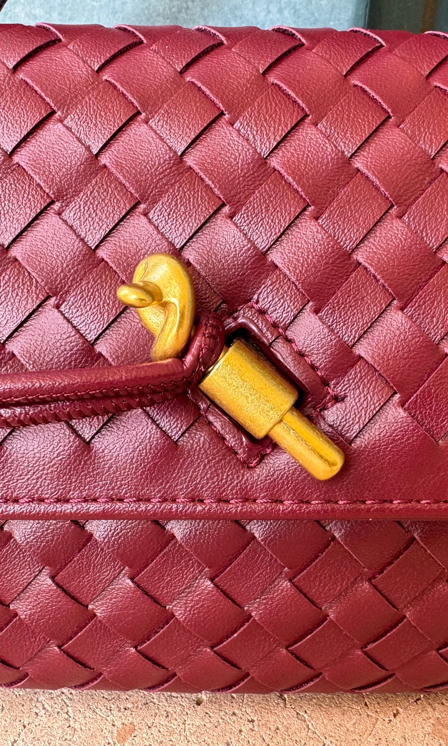 Maroon woven faux leather handbag with top handle and detachable shoulder strap