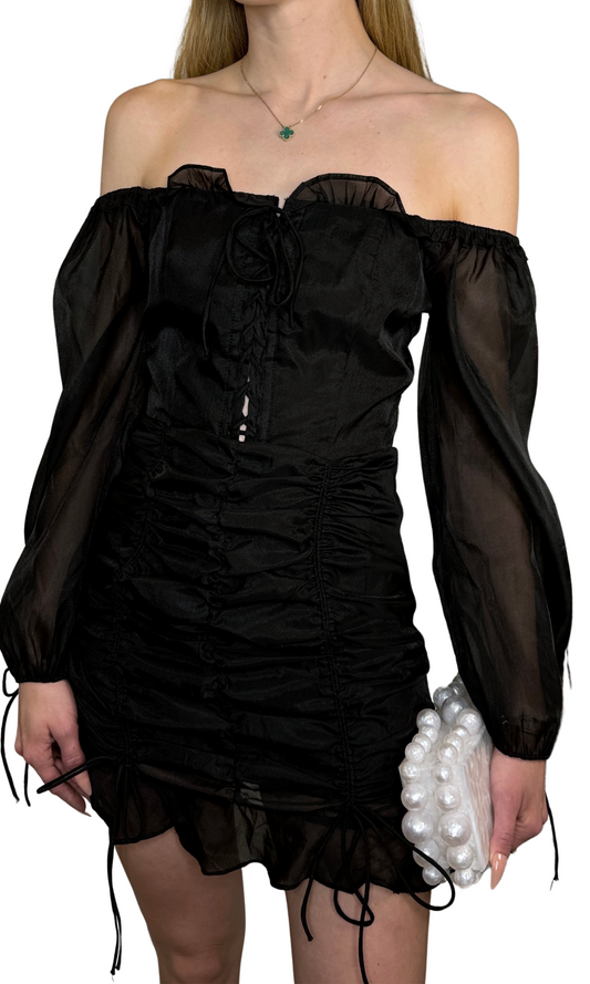 Off-the-shoulder black organza semi-sheer dress featuring lace-up front detail, ruched skirt with ties, balloon sleeves with ruffle and ties, and center back zipper, perfect for a timeless romantic look.